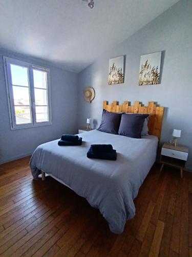 une chambre avec un grand lit avec deux oreillers dessus dans l'établissement linge fourni 3 etoiles Proche mer et centre ville, à Saint-Gilles-Croix-de-Vie