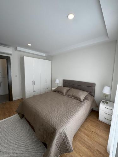 a bedroom with a large bed and white cabinets at Su Apartment Side in Side