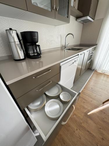 a kitchen with white plates sitting in the drawer at Su Apartment Side in Side