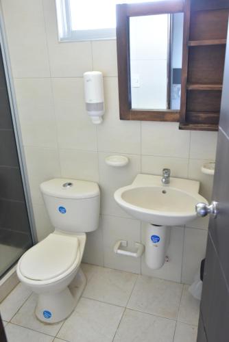a bathroom with a toilet and a sink at Hotel Iguaraya Inn in Ríohacha