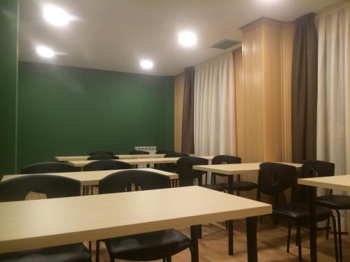 uma sala com mesas e cadeiras e uma parede verde em Mirador El Silo em Bello