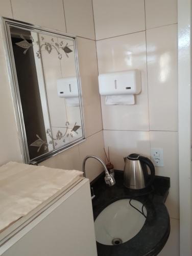 a small bathroom with a sink and a mirror at Casa em meio a natureza in Chapecó