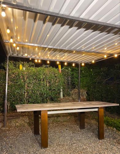 a wooden bench sitting under a canopy with lights at Cabañas Murmullos del arroyo in Choachí