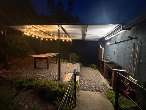a patio with a table and lights on it at Cabañas Murmullos del arroyo in Choachí