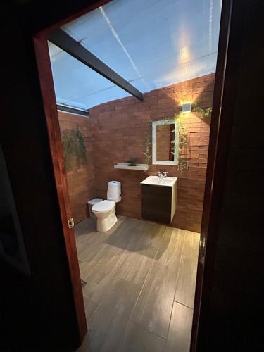 a bathroom with a toilet and a sink at Cabañas Murmullos del arroyo in Choachí
