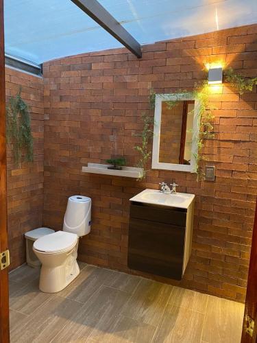 a bathroom with a toilet and a sink at Cabañas Murmullos del arroyo in Choachí