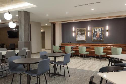 a dining room with tables and chairs and a bar at Fairfield by Marriott Inn & Suites Cincinnati Oakley in Cincinnati