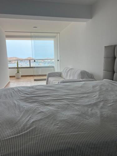 a bedroom with a bed with a view of the ocean at Ocean View Premiere Depa Naplo in Naplo