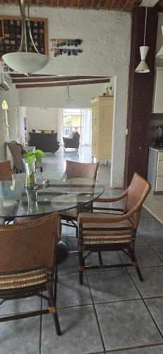 a dining room with a glass table and chairs at Casa, terraza con alberca, la Cañada in Ixtlahuacán de los Membrillos