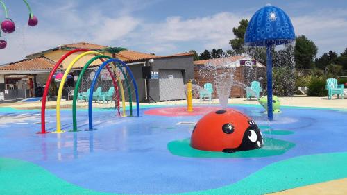 a water park with a playground with a ball in the water at MOBIL-HOMES LES CHARMETTES 4 Etoîles in Les Mathes