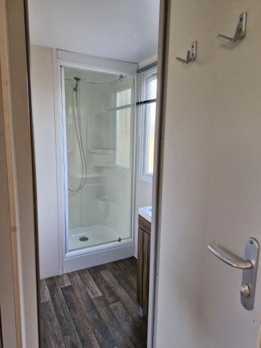 une salle de bain avec douche et porte vitrée dans l'établissement MOBIL-HOMES LES CHARMETTES 4 Etoîles, aux Mathes