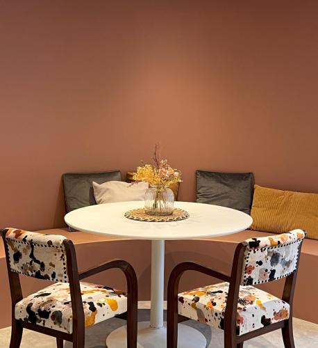 d'une table avec deux chaises et d'un vase avec des fleurs. dans l'établissement NOUVEAU ! Le Ptit Brou, à Bourg-en-Bresse