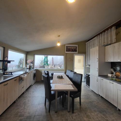 a kitchen with a table and chairs in it at Dumbrava Ursului in Zărneşti