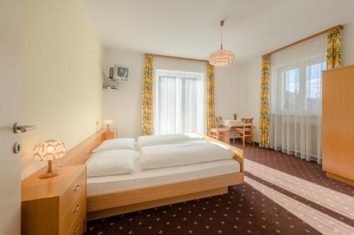 ein Schlafzimmer mit einem großen Bett und einem Tisch in der Unterkunft Garni B&B Apartments Plank in Welschnofen