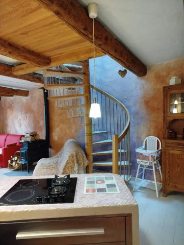 une cuisine avec cuisinière et un escalier en colimaçon dans l'établissement Eco-gîte cottage panoramique, terrasses, baby foot, 150 m2 rénové et agrandi en 2024, activités proposées, à Champagnac-le-Vieux