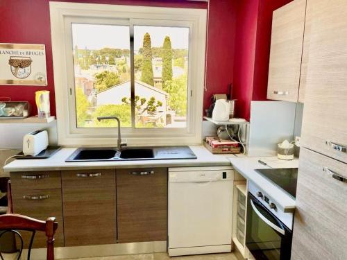 une cuisine avec un évier et une fenêtre dans l'établissement Plein centre type 3 avec parking, à Sanary-sur-Mer