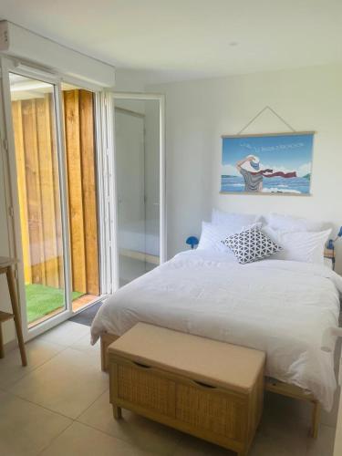 une chambre avec un lit blanc et une grande fenêtre dans l'établissement Cabane de Pénélope avec spa privé centre-ville et plage, à Andernos-les-Bains