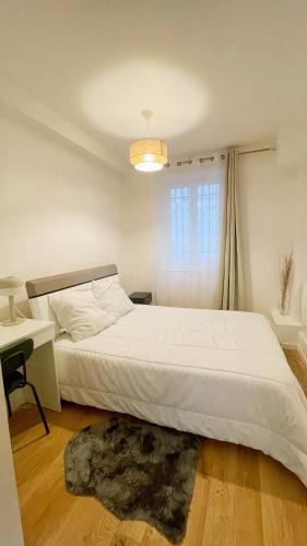 une chambre avec un grand lit blanc et un bureau dans l'établissement Lux Home Le Marais, à Paris