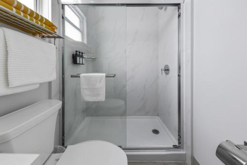 a bathroom with a shower with a toilet and a sink at Affordable Luxury Apartments, 3 Min to Beach in West Bay