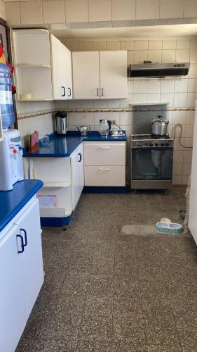 a kitchen with white cabinets and a blue counter top at Casona Campillay in La Serena