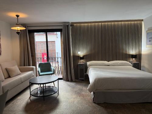 une chambre avec un lit, un canapé et une table dans l'établissement Placentines, à Séville