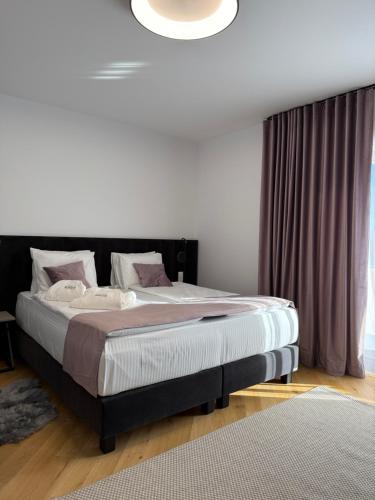 a bedroom with a large bed with a black headboard at Marmotta Paltinis in Păltiniş