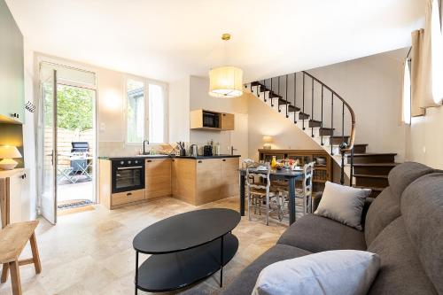 a living room with a couch and a table and a kitchen at Au coeur de Marlotte in Bourron-Marlotte
