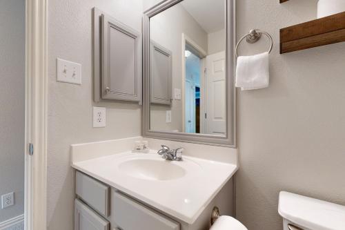 a white bathroom with a sink and a mirror at Living the Dream in San Antonio