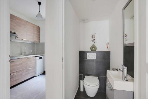 une salle de bain blanche avec des toilettes et un lavabo dans l'établissement Modern apartment - 2BDR 6P - Paris 14e, à Paris