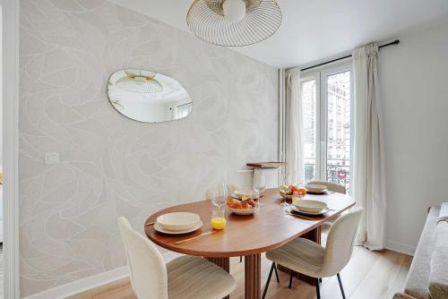une salle à manger avec une table et des chaises en bois dans l'établissement Modern apartment - 2BDR 6P - Paris 14e, à Paris