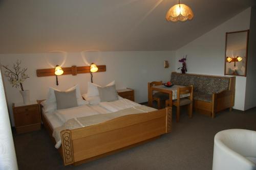 a bedroom with a bed and a table and a chair at Pension Andrea in Sankt Peter im Sulmtal