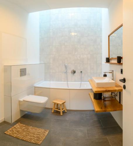a bathroom with a tub and a toilet and a sink at Pausenhof Spreewald in Unterspreewald