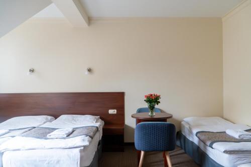 a hotel room with two beds and a table at Nad Borkiem in Kosarzyn