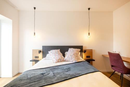a bedroom with a large bed with two pillows at L'ile chaumette in Épervans