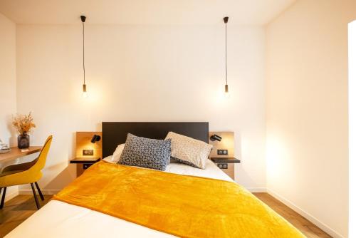 a bedroom with a bed with a yellow blanket on it at L'ile chaumette in Épervans