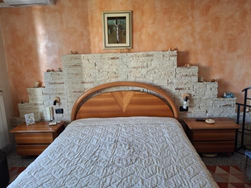 a bedroom with a bed and a stone wall at Al Civico Centocinquantasei in Latiano