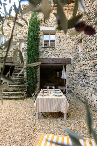 una mesa en el patio de un edificio de piedra en Haven of peace in luberon, en Cabrières-dʼAvignon