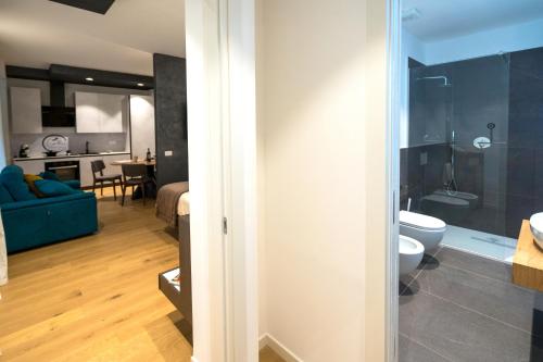 a bathroom and a living room with a blue couch at Callas Luxury Suite Verona in Verona