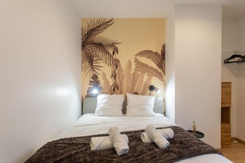 - une chambre avec un lit et 2 chaussons blancs dans l'établissement La chute des feuilles - Lit double- T2 Hyper centre, à Abbeville