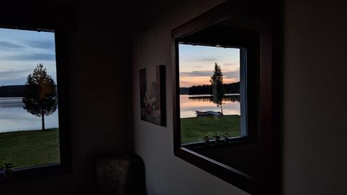 a mirror in a room with a view of a lake at Lakeview Houses Sweden - Red House in Svärdsjö
