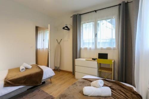 una camera da letto con due letti, una scrivania e una finestra di La chute des feuilles - 2 Lits simples - T2 Hyper centre a Abbeville
