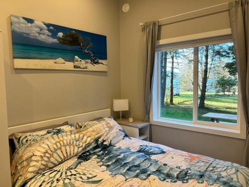 a bedroom with a bed and a window at The Cottage - A Private Oceanfront Dream! in East Sooke
