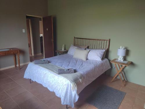 a bedroom with a bed with a blue comforter at The View Holiday Home in Graskop
