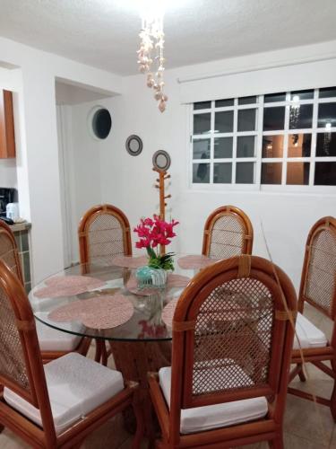 a dining room with a glass table and chairs at Depto con PISCINA PUENTE DEL MAR ACAPULCO in Acapulco