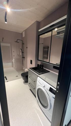 a kitchen with a washing machine in a room at New and modern Scandinavian style apartment in Sigulda