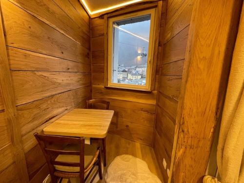 une petite pièce en bois avec une table et une fenêtre dans l'établissement La clé dorée - Studio chalet départ télécabines, à Cauterets
