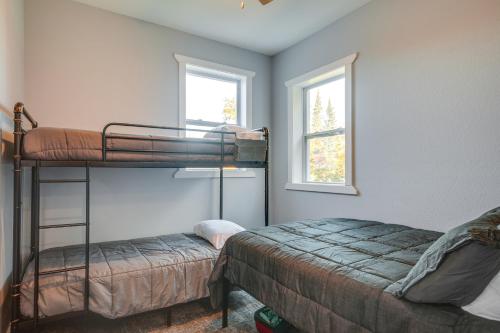 a bedroom with two bunk beds and two windows at 15 Mi to Lake Superior Renovated Church with Grill in Toivola