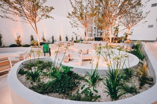 a garden venue with white furniture and trees at Hotel Denver Mar del Plata in Mar del Plata