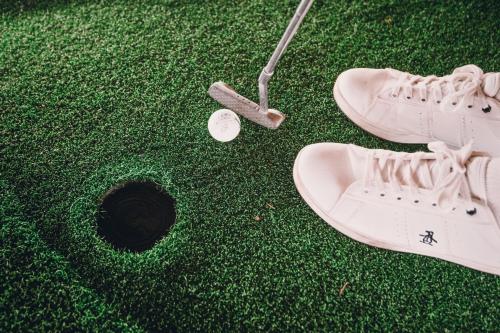 a pair of shoes and a golf ball on a putting green at Hotel Denver Mar del Plata in Mar del Plata