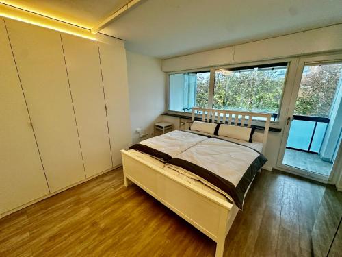 une chambre avec un lit et une grande fenêtre dans l'établissement Moderne 3-Zi, King-Size Betten, Küche, Badewanne, à Karlsruhe